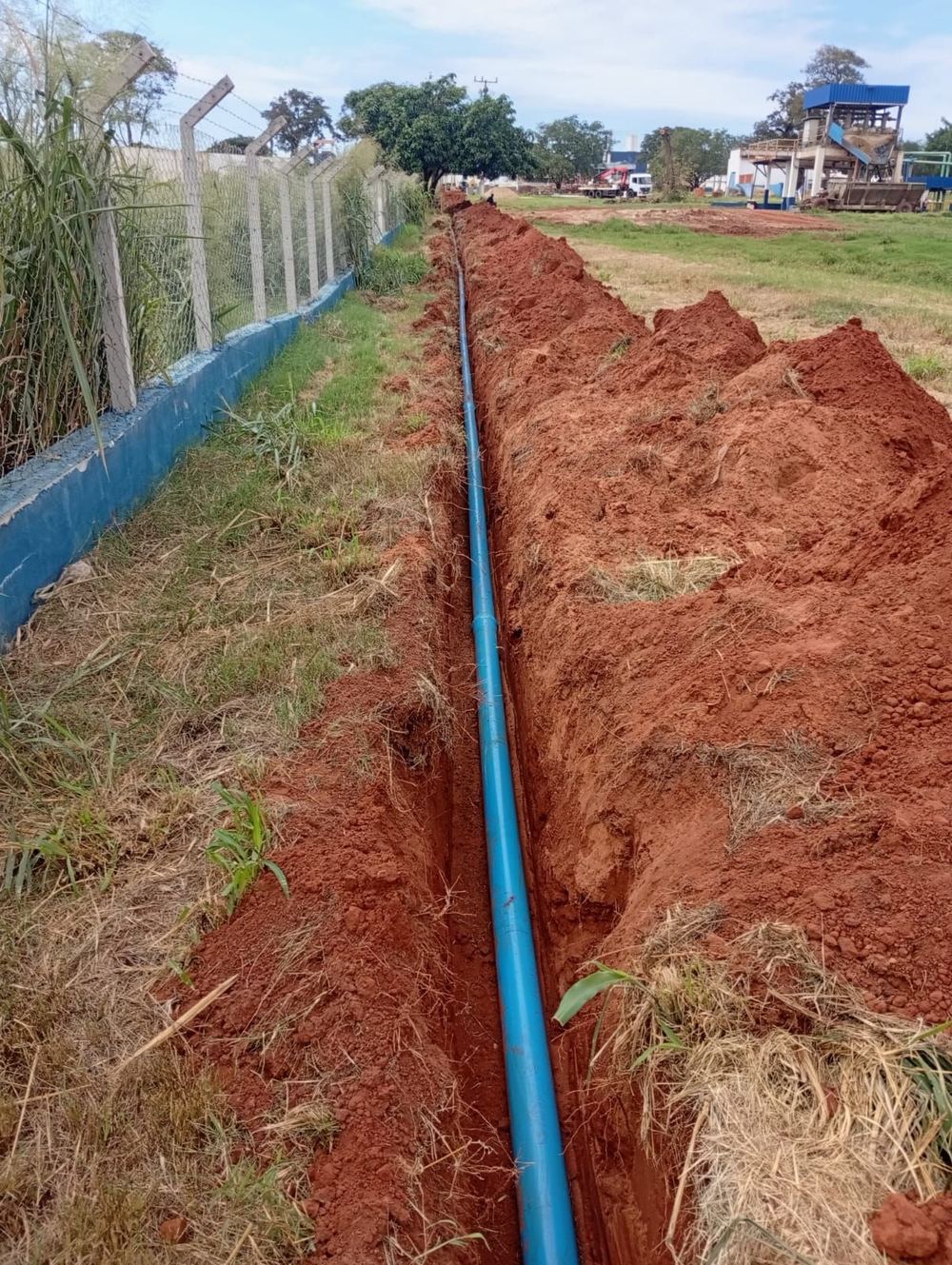 Vala com tubulação de PVC ao longo de cerca
